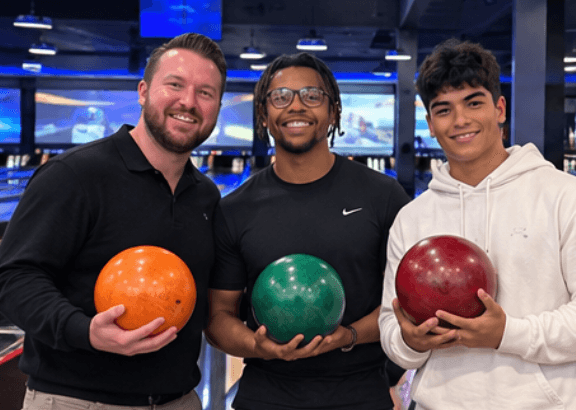 Revamped Marketing team members holding bowling balls during a team outing